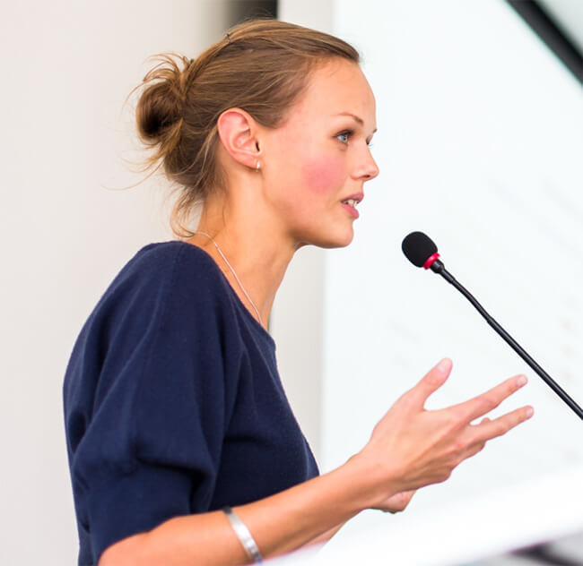 Female tutor giving a lecture with a microphone at Tutor Pro